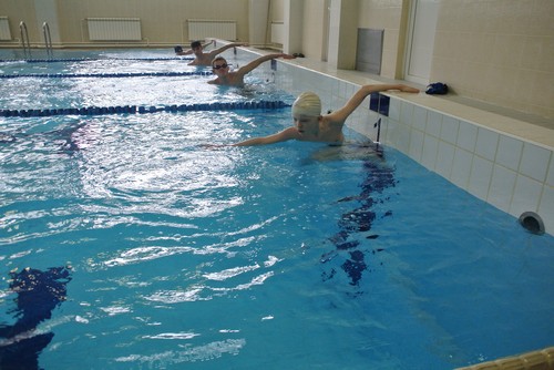 Skolēni baseinā gatavi peldējuma startam.