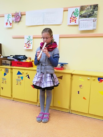 Meitene spēlē flautu