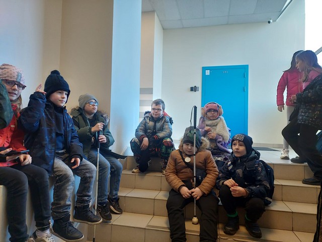 Skolēni sēž uz trepēm.