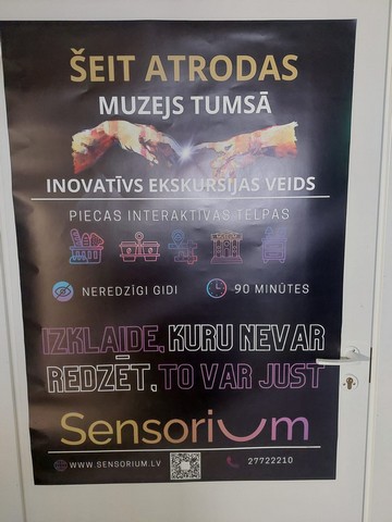 Afiša pie durvīm: Šeit atrodas muzejs tumsā.