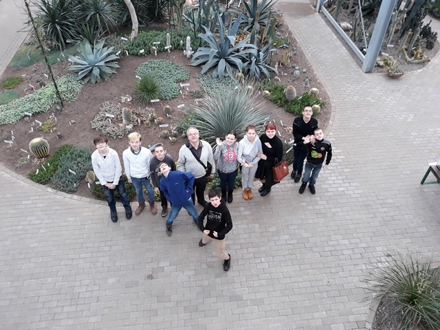 Visa klase ar skolotāju botāniskajā dārzā. Fotogrāfēts no augšas.
