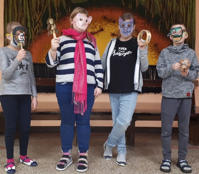 4 skolēni maskās stāv skolas koridorā