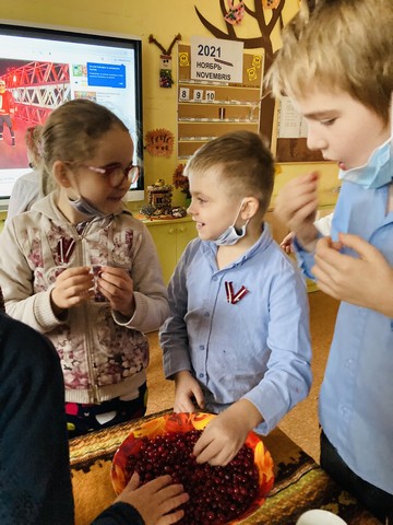 Bērni klasē pie galda garšo dzērvenes