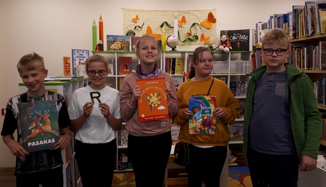 5 Skolēni bibliotēkā rāda savas grāmatas 