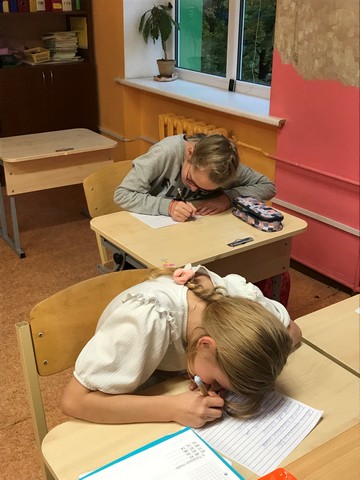 Divas skolnieces raksta burtnīcās.
