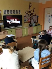 Skolēni klasē skatās filmu "Kas ir Latvija".