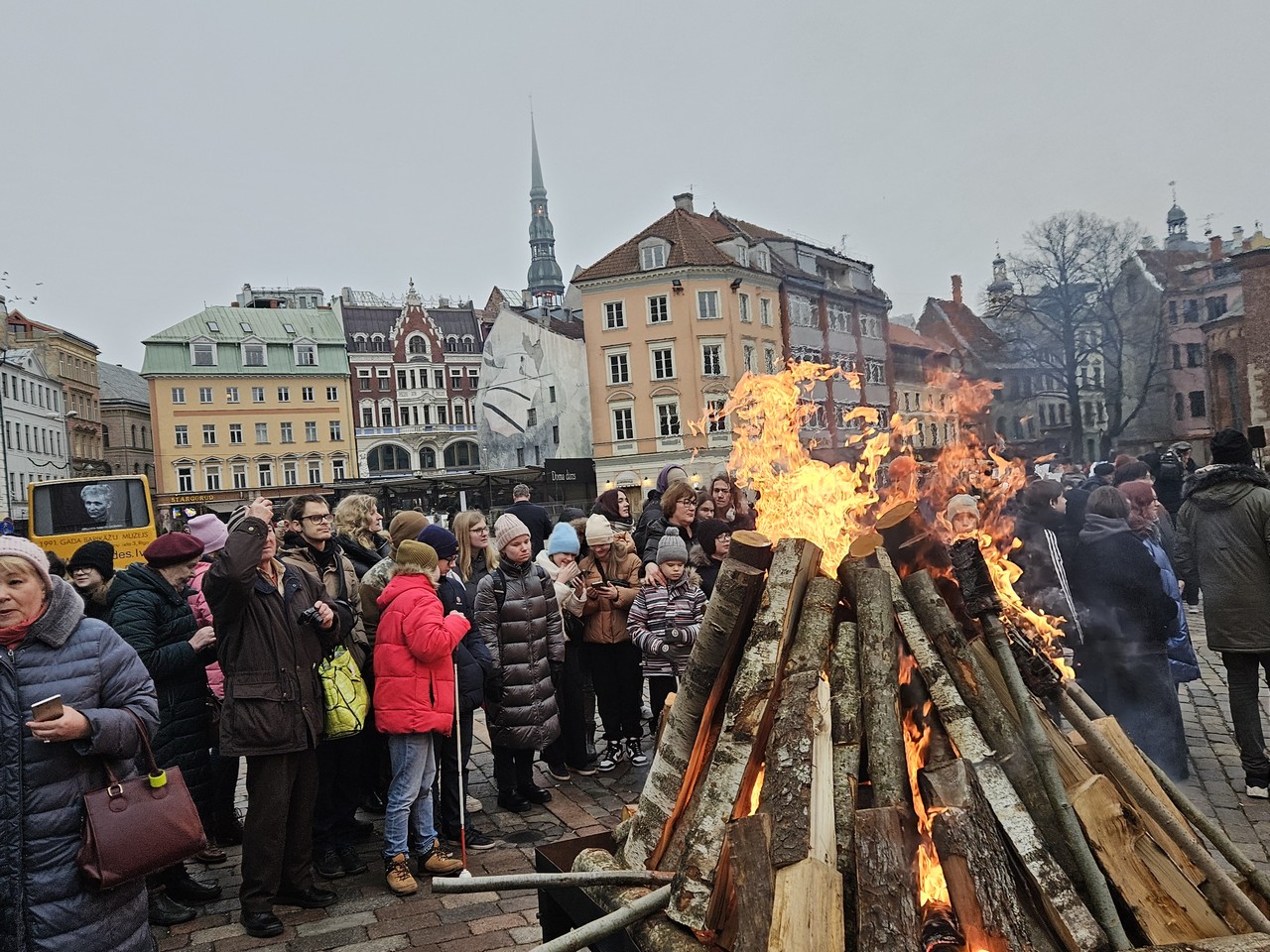 Skolēni pie liela ugunskura.