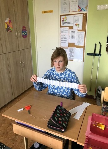 Skolniece ar papīra loksni.