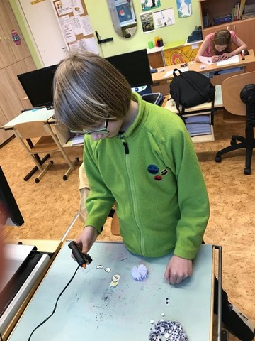 Zēns ar līmes pistoli lipina lapiņas.