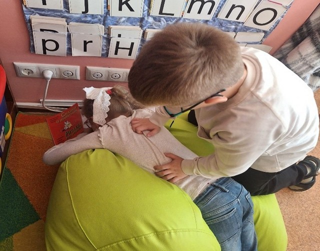 Zēnes veic meitenei mākslīgo elpināšanu.