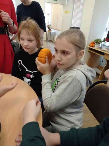 Meitene tur rokās mazu ķirbi.