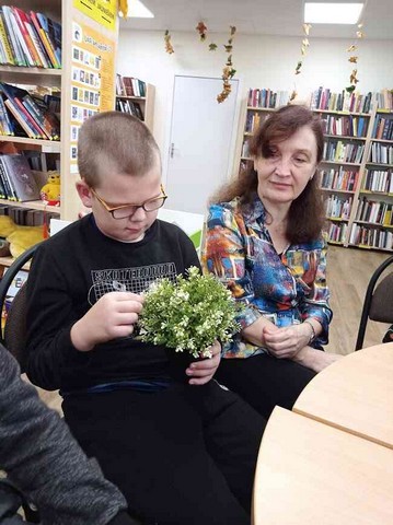 Zēns tur rokās pruķu pušķi.