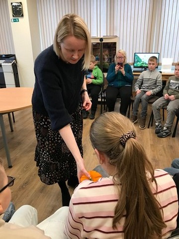 Bibliotekāra dod meitenei ķirbi.