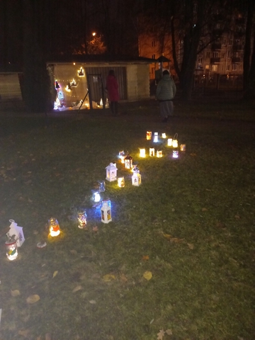 Pļaviņā gaismas ceļš no aizdegtām svecītēm.