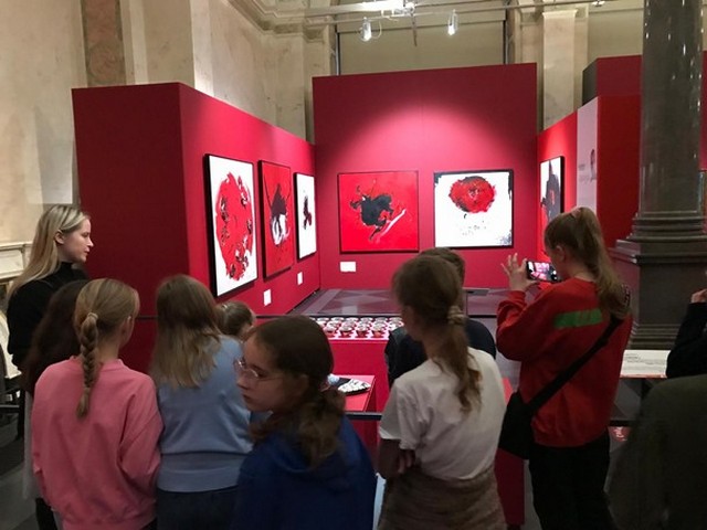 Skolēni sastājušies pie izstāžu stendiem.