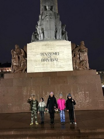 Pieci skolēni pie brīvības pieminekļa.