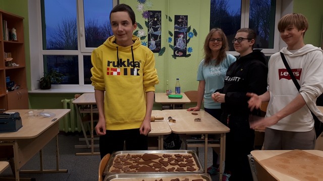 Četri skolēni nostājušies pie pannām ar piparkūkām, kas sagatavotas cepšanai.