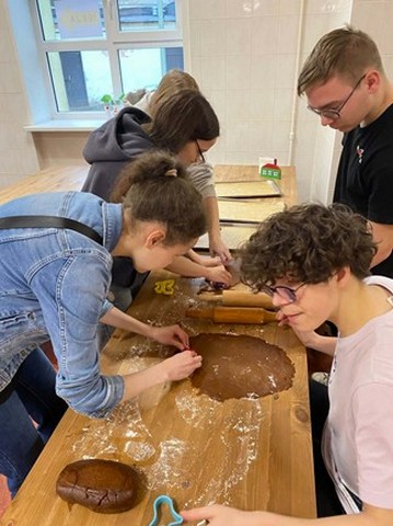 Četri skolēni veido piparkūkas ar formiņām.