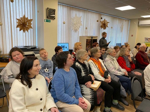 Skolēni un citi pasākuma dalībnieki klausās.