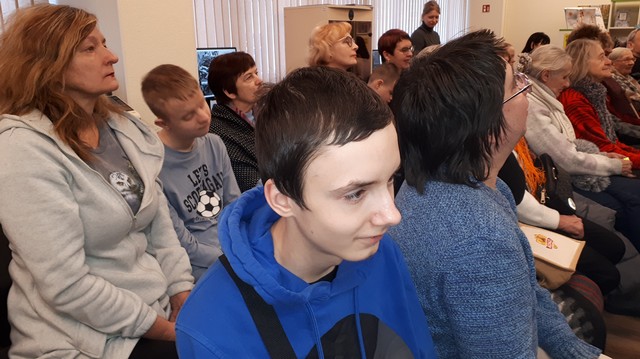 Skolēni bibliotēkas zālē uzmanīgi klausās.