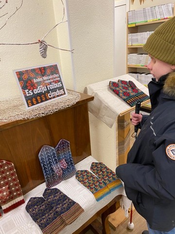 Alberts apskata adītus cimdus.