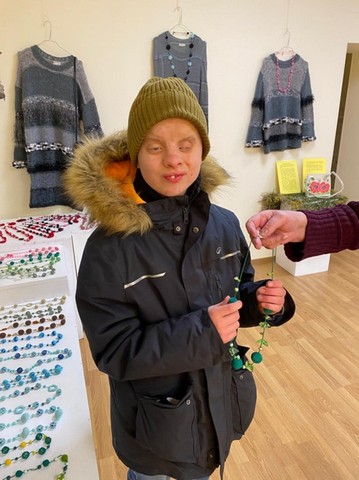 Alberts tur rokās krelles.