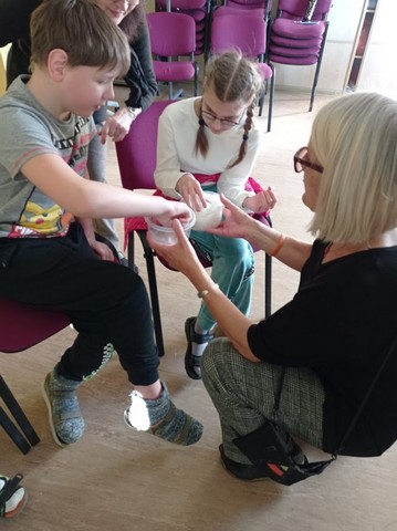 Terēza dod skolēniem aptaustīt trauciņos esošo.