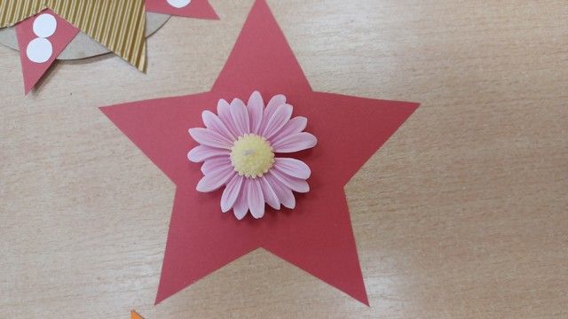 Piecstaru sarkana zvaigzne, uz kuras svece kā zieds.