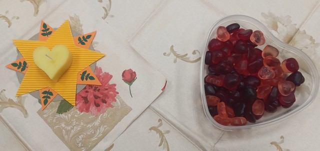 Divi trauciņi - vins ar lapām un sveci, otrs ar želejas konfektēm.