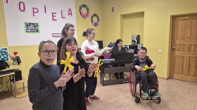 Uzstājas četras meitenes un viens zēns, kurš ir ratiņkrēslā.