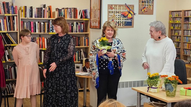 Bibliotekāres ar ziediem., blakus skoloāja Inese ar skolnieci.