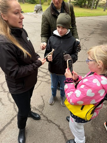 Zooloģiskā dārza darbiniece stāsta skolēniem.