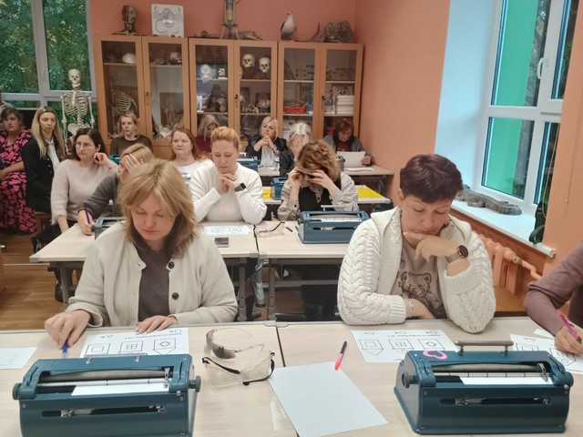 Kursu dalībnieces apskata reljefus zīmējumus.